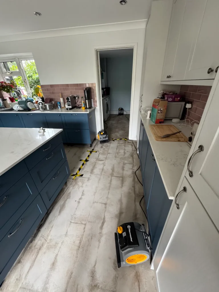 Flood damage is visible in a kitchen corridor where Rajvar has begun the drying process.